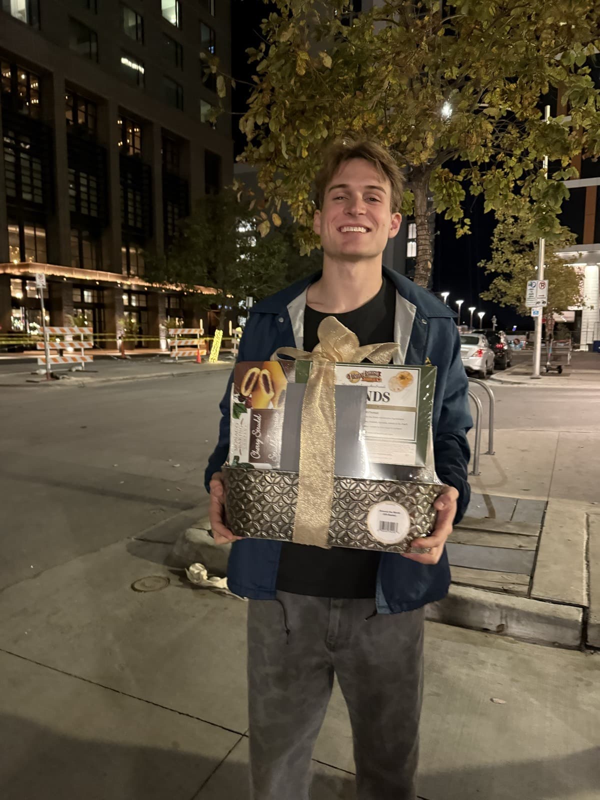 Brendan Bennett holding a gift basket in downtown Austin