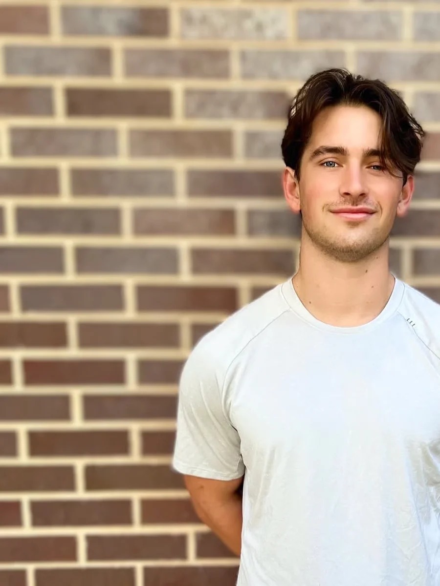 Close crop of Brendan Bennett in front of a brick wall