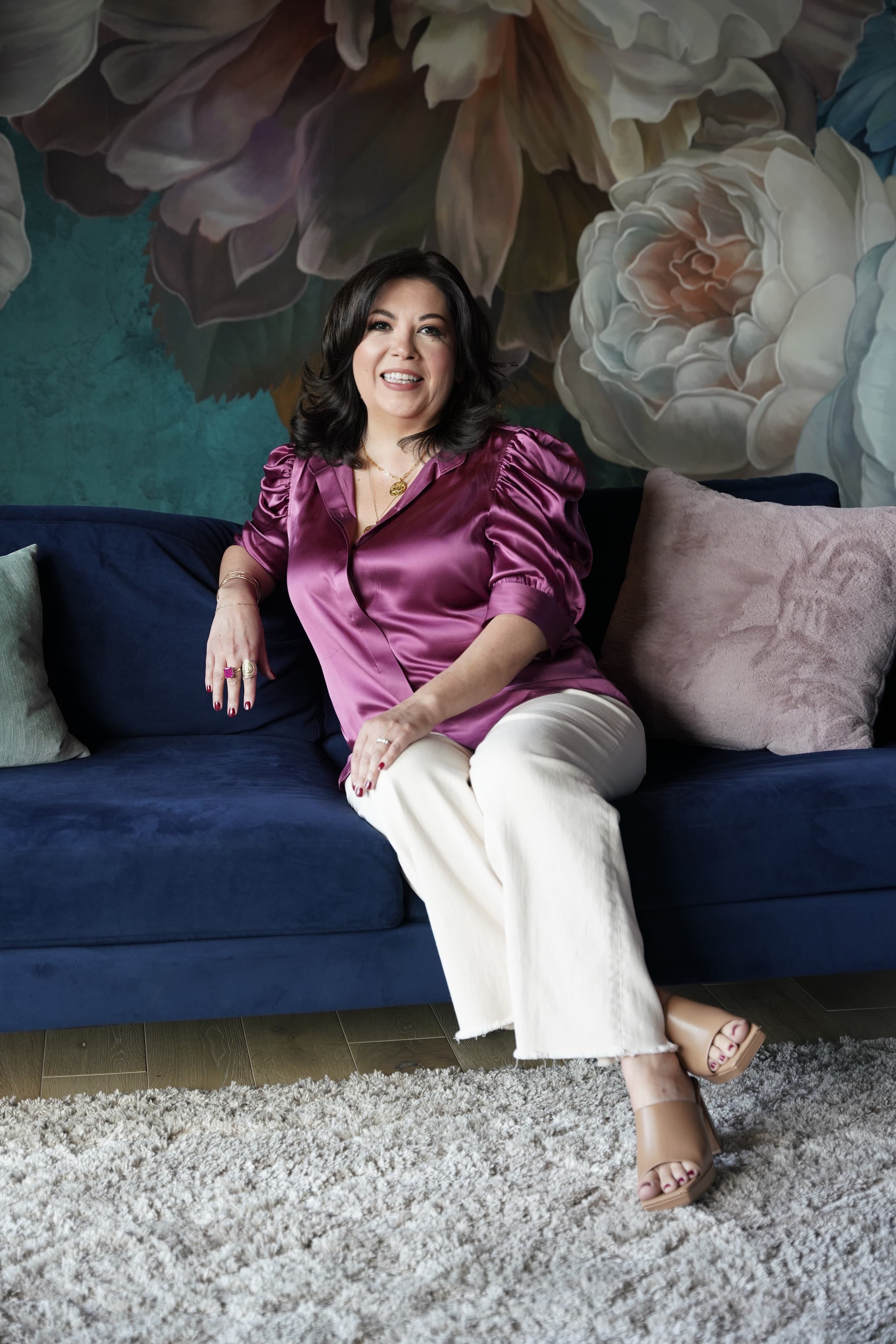 Laura Macias seated on a pink sofa